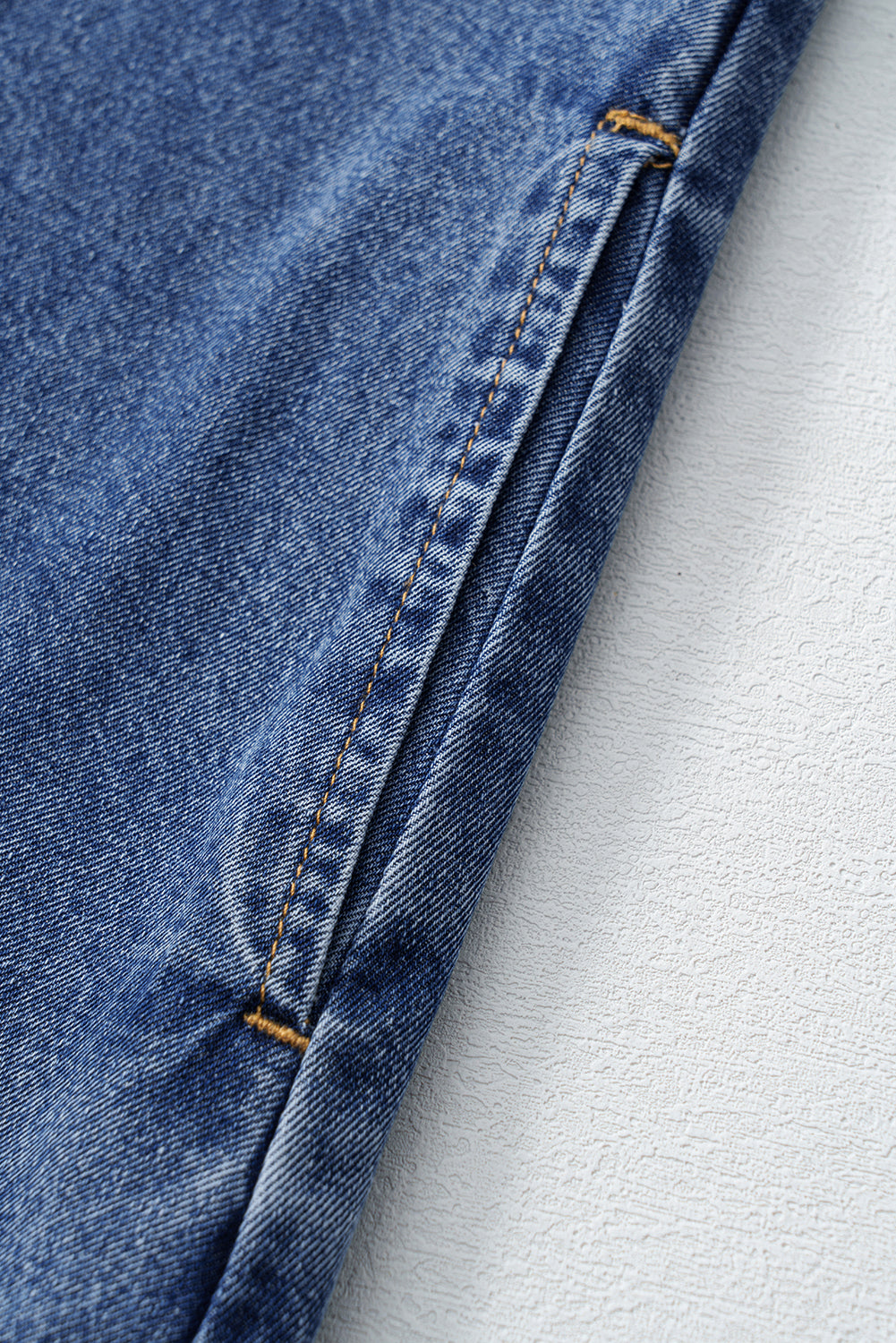 Close-up of blue denim fabric on a light gray background